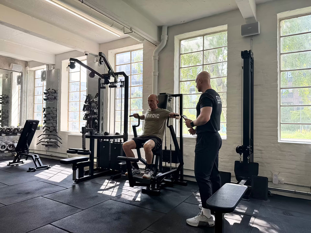 Person med kroniske smerter gennemfører gradvist stigende styrketræning under vejledning af fysioterapeut